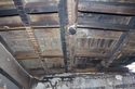Thumbnail of The ceiling of the south bedroom showing the evidence for lath and plaster, with the modern wall lining beyond, looking south