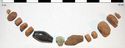 Thumbnail of Plate 8: The Composite Bead Necklace from the Barrow 3 inhumation: the faience bead is central, to its left is the jet bead and to its right the bead made of shale. The remaining components are of amber.