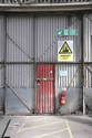 Thumbnail of Former vehicle storage shed 20, typical red painted MOD fire exit door