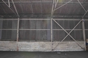 Thumbnail of Former vehicle storage shed 20, concrete blockwork foundations and plinth with corrugated sheeting above 