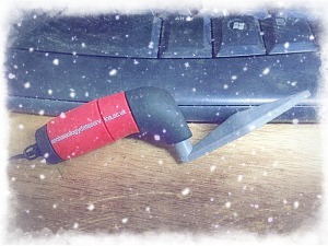 Photograph of an ADS trowel shaped USB memory stick on a desk with stylised snow overlaid over the photograph.
