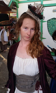 Image of Teagan, a white, fem person wearing a pirates outfit and a ship hat.