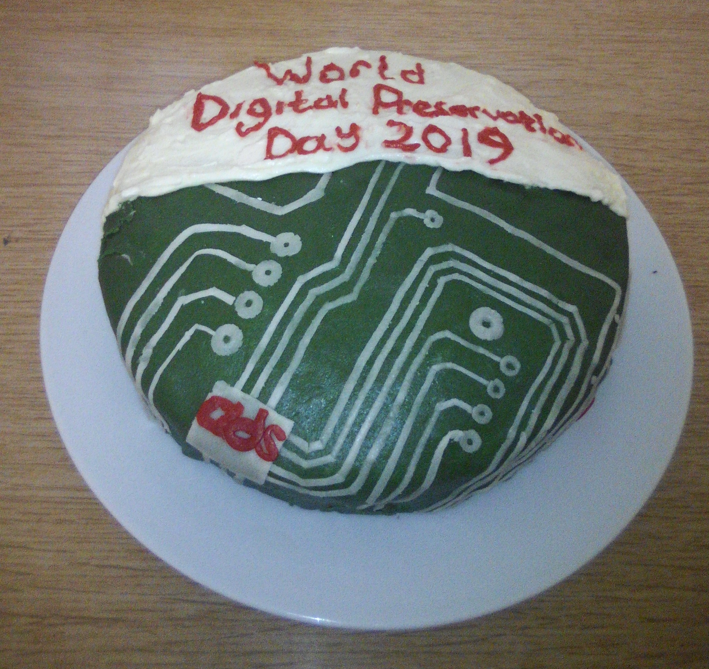 A cake with a green and white circuit board design and the text 'World Digital Preservation Day 2019'.
