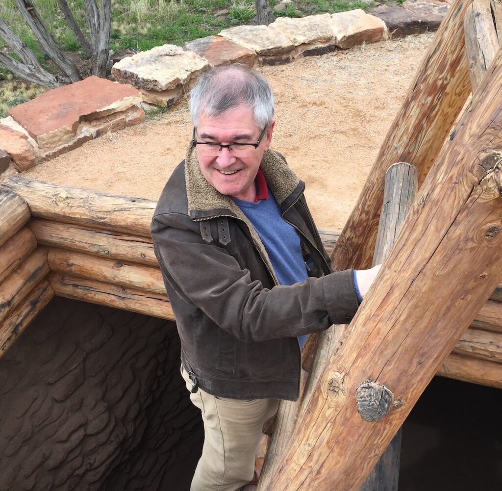 Photo of Julian Richards climbing out of a Pueblo kiva