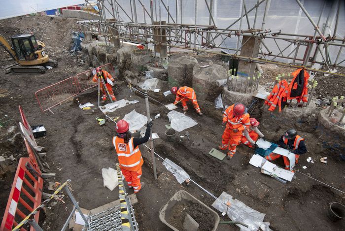 A group of Crossrail archaeologists excavating and recording an archaeological site