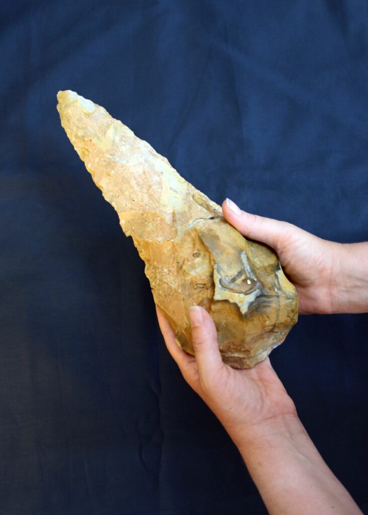The hands of a person holding a giant handaxe