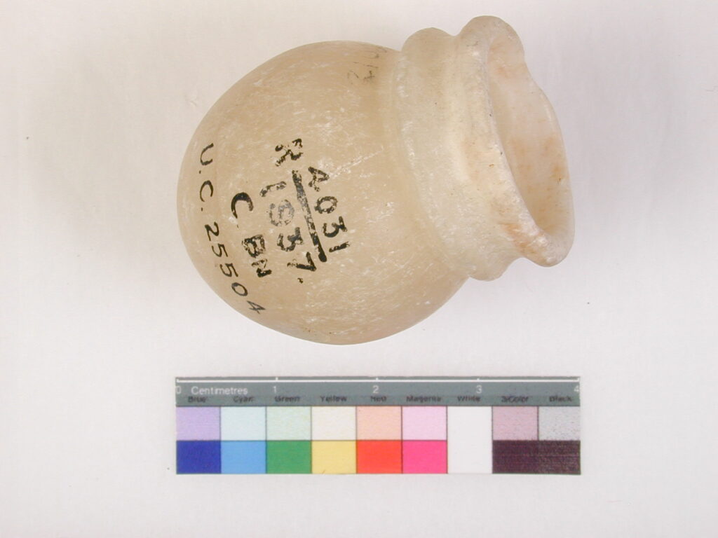 A small glass object with black writing on the side