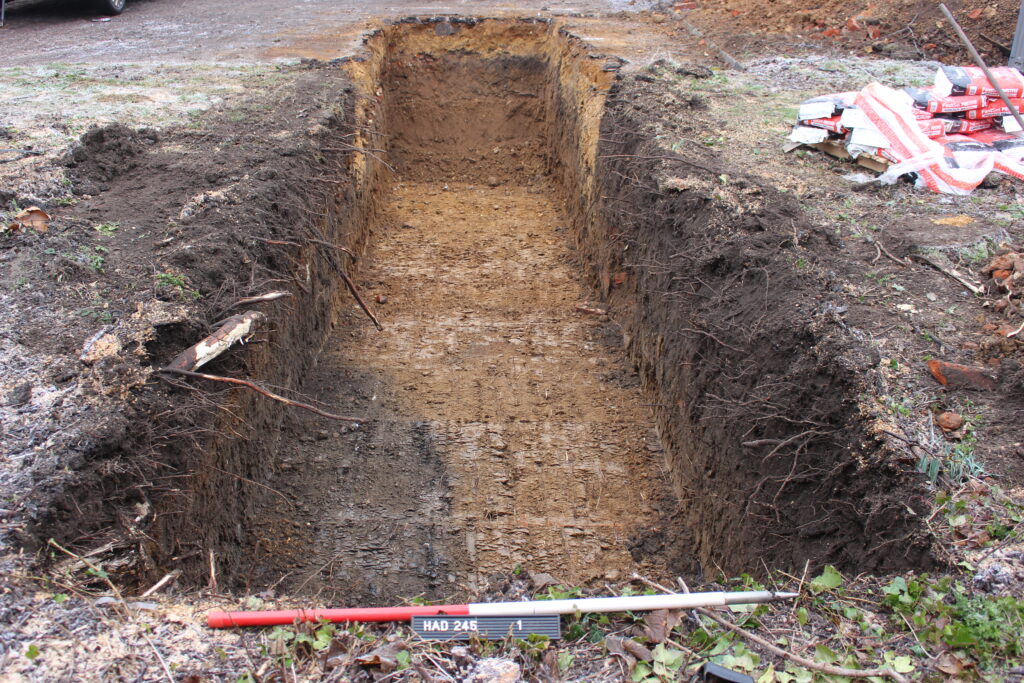 A picture of an excavated trech with a 1m scale bar