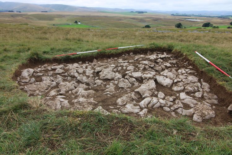A small excavation of a hill revealing stonework