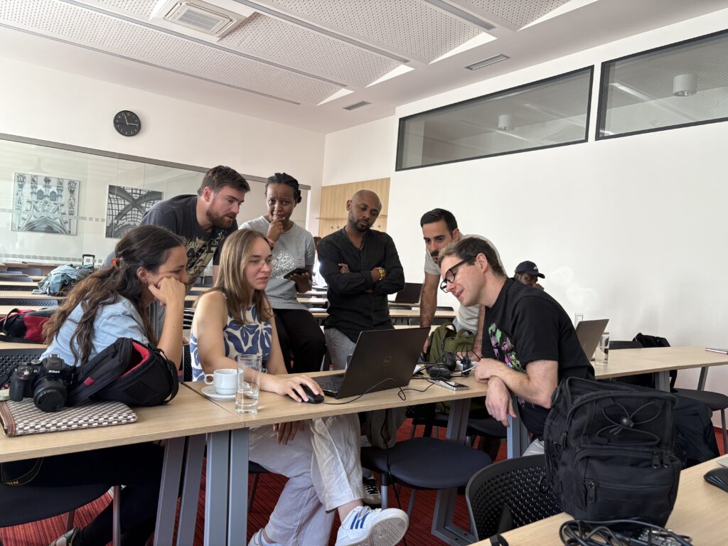 Summer school participants posing around a computer 