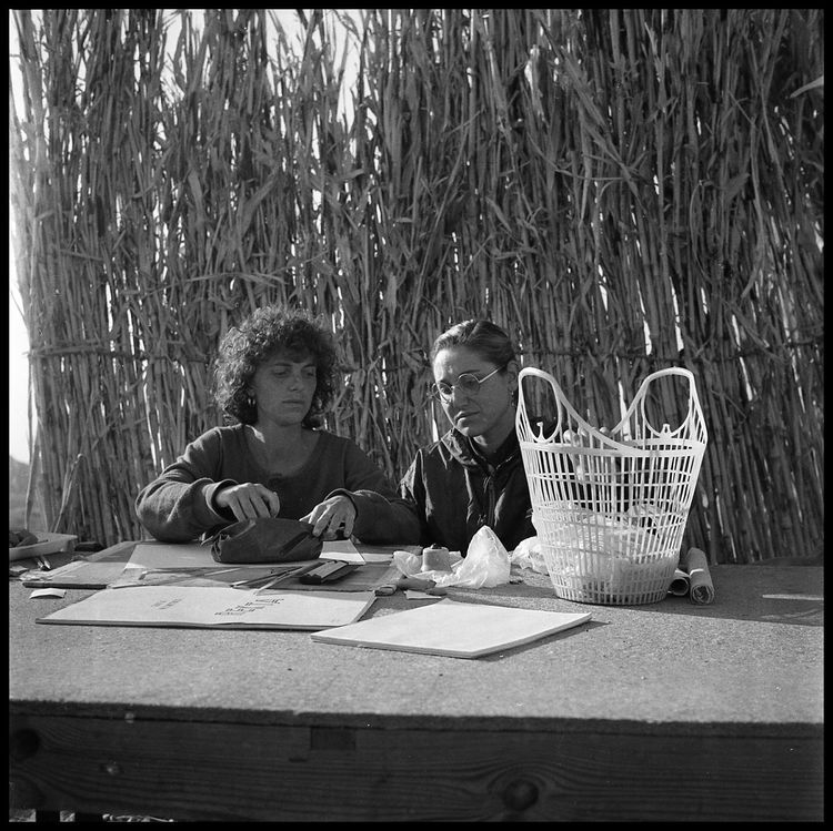 A black and white image showing two team members sorting finds  