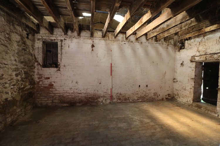 Thumbnail of Figure 20 and 65 Interior of cowshed Room B4 looking west with window opening to carriageway entrance