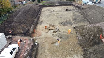 Drone image of overall site with excavation and surveying. View west