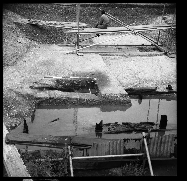 Thumbnail of 56-6 View looking N of Beams A and B during excavation in Great Ditch II including archaeologist with scale