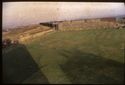 Thumbnail of 1972 photograph of Area C, Site XXIII (Outer Courtyard) prior to excavation, looking east from roof of Turret House, showing wall of Long Gallery.