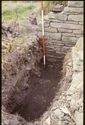 Thumbnail of 1988 photograph showing excavated rectangular feature at foot of standing wall in Cruck Building.