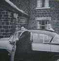 Thumbnail of Black and white photograph, c.1960, showing a man and a woman getting into a car outside of Colliery House, next to Cruck House. Reverse handwritten text reads 