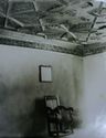 Thumbnail of Black and white photograph of interior of building in Sheffield Manor Lodge, showing moulded ceiling decoration, chair, and square mirror.