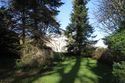Thumbnail of Treloyhan Manor’s south front through trees