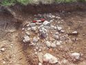 Thumbnail of Cleaned Area (1102) showing pottery and quern stone Area B