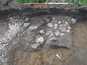 Thumbnail of Photograph depicting a cluster of stones [103] taken during archaeological evaluations at Milken Lane, Ashover, Derbyshire (1m scale) No board
