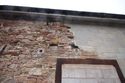 Thumbnail of Detail of break between surviving fabric and breeze block repairs, facing south west. Note the surviving metal and wood fixtures here that are likely part of the now lost building.
