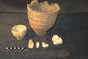 Thumbnail of Plate 9: The Barrow 2 inhumation grave group: Food Vessel, small accessory vessel, three flint knives and a carved sandstone bowl.