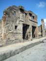 Thumbnail of A bakery retrofitted into a two storey house (8.4.27), left, and a shop for bread (8.4.26), right. Another shop (8.4.25), far right. Copyright Sera Baker, 2016.