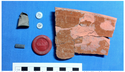 Thumbnail of Some of the artifacts recovered from the Octagon House. A metal thimble, two buttons (glass and shell), a fragment of slate pencil, a plastic checker piece, and a fragment of a large milk pan.