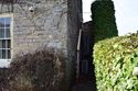 Thumbnail of E elevation, external passage between N gable and roadside wall, looking W