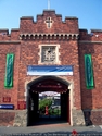 Thumbnail of Militia Barracks (Burton Road/Upper Long Leys Road, Whitton Park, Ermine West, Lincoln, Lincolnshire). Castellated brick buildings around courtyard. Crest above tower entrance archway of Royal North Lincolnshire Militia. Front elevation, Burton Road.