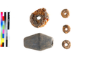 Thumbnail of the 4 annular amber beads and a biconical jet or shale bead from context 1052