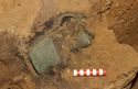 Thumbnail of The eastern mediterranean flagon in siu during excavation, 0.10m scale