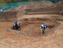 Thumbnail of The slumped fills of the former mound, collapsed into the chamber grave, being photo cleaned by mike house & andy leonard.