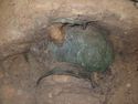 Thumbnail of The east mediterranean copper alloy basin <3> suspended on fe hook <175> on the east wall of the chamber, supported on its partially excavated soil block.