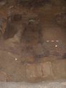 Thumbnail of General view of north side of chamber, following the initial block lifting of the suspended grave goods. The photo shows the filtration deposits around the coffin, and semi-circular negative feature [251] against the north wall. The fe folding stool <6> & iron bound tub <7> are in the foreground.