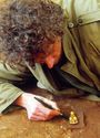 Thumbnail of Excavation supervisor ian blair carefully revealing the gold buckle