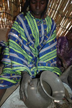 Potter from Ayingam, southwest Niger, using a twisted cord roulette to decorate the neck of a vessel prior to firing. Photo: Olivier Gosselain