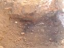 Thumbnail of Excavated test pit 23, brick walls and flag stone from N
