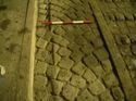 Thumbnail of Worn linear groove in the cobbled surface of Milk Ramp. An iron rail is to the right.