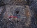 Thumbnail of Trench 10. Concrete plinth [1002] for roof column of 1906 engine shed with brick manhole behind